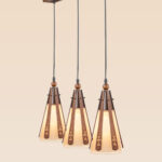 Triple pendant light with floral-carved wood slats and frosted glass cones suspended from a long wooden rectangular base – Checkmark Model 22h3 – perfect for dining tables or kitchen islands