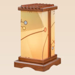 Modern wooden table lamp with geometric-patterned acrylic panels and soft amber glow, handcrafted by DARKAR