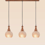 Horizontal triple pendant light with wooden tops and frosted globe shades – Checkmark Model 60h3 – rustic linear hanging light for kitchen islands and dining spaces