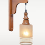 Wooden wall sconce light with cylindrical frosted glass shade – distributed by Checkmark, crafted by DARKAR Lighting Industries.