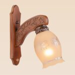 Wooden wall sconce light with floral-etched frosted glass shade – distributed by Checkmark, crafted by DARKAR Lighting Industries.