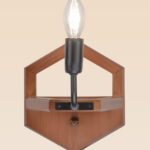 Wooden wall sconce light with hexagonal backplate and exposed candle-style bulb – distributed by Checkmark, crafted by DARKAR Lighting Industries.