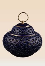 Detail of openwork ceramic lidded jar showing cut-out pattern and ring handle