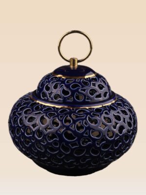 Detail of openwork ceramic lidded jar showing cut-out pattern and ring handle