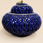 Openwork ceramic lidded jar with glossy glaze and sculptural form