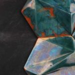 handcrafted ceramic decorative tile with faceted green glaze and amber accents