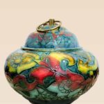 Patina glaze ceramic lidded jar with layered color tones and sculptural form