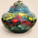 Patina glaze ceramic lidded jar with layered color tones and sculptural form