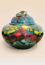 Patina glaze ceramic lidded jar with layered color tones and sculptural form