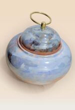 Refined glaze ceramic lidded jar with smooth surface and sculptural form top side view