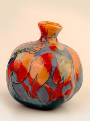 Incised ceramic pomegranate with handmade carved pattern and layered glaze
