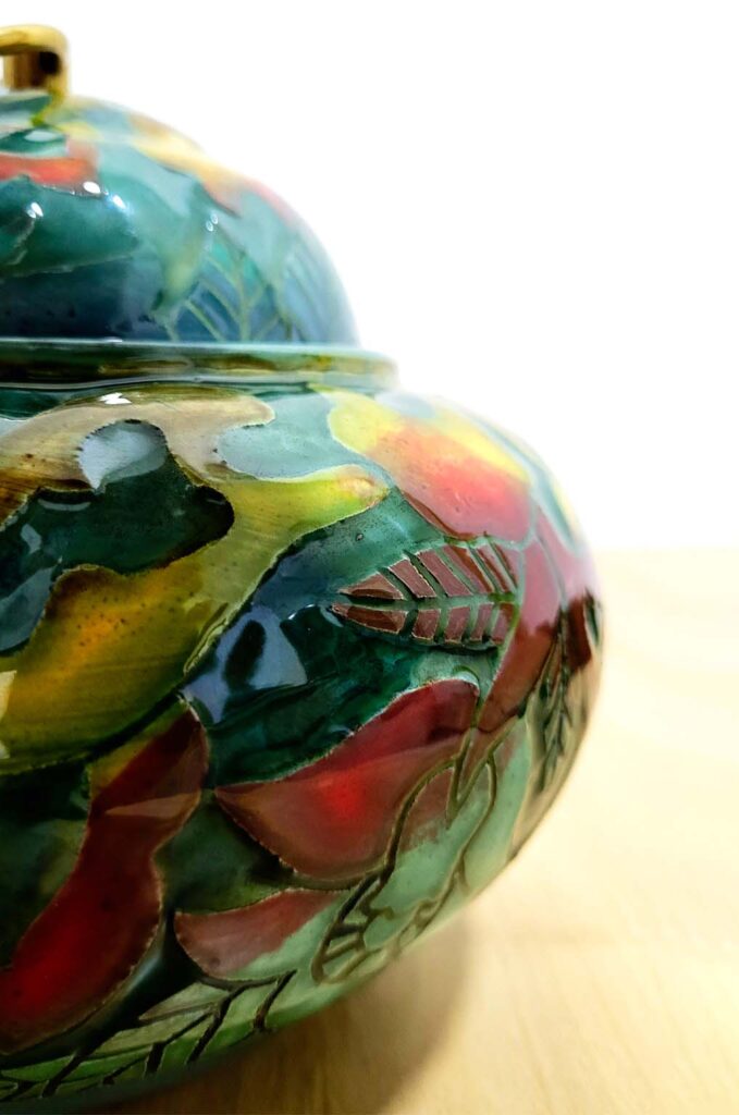 Ceramic lidded jars displayed on shelves with ceramic art objects and books