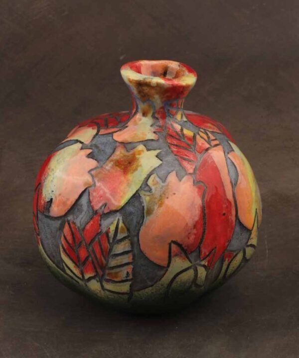 Ceramic pomegranate décor styled on a refined console table with warm lighting