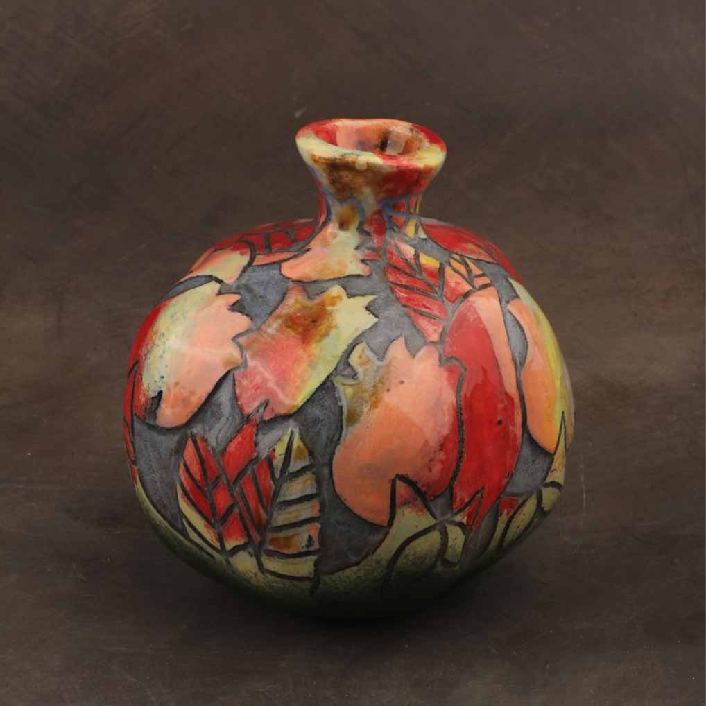 Ceramic pomegranate décor styled on a refined console table with warm lighting